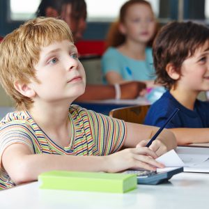 Kind im Unterricht in der Grundschule schreibt linkshändig